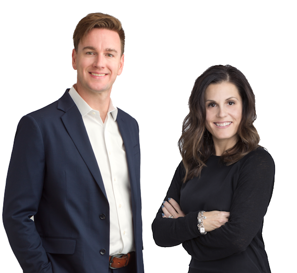 A portrait of Scott Land & Lease staff Cameron Gillies, Mineral Administrator, and Celeste Farrow, Surface Manager, standing side by side against a white background. Cameron is on the left and is wearing a navy blue suit with a white shirt, smiling. Celeste is on the right and is wearing a black top with her arms crossed, also smiling. Both are looking directly at the camera, conveying a sense of confidence and professionalism.