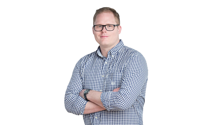 A portrait of Scott Land & Lease staff Dave Gieg, Manager, Infrastructure and Special Projects. Dave has short blonde hair and glasses, wearing a black and white checkered shirt. He is standing with his arms crossed, looking directly at the camera with a neutral expression. The background is plain white, highlighting his professional appearance.